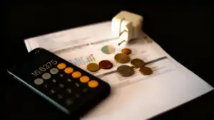 Calcolatrice, monete e presa elettrica su una bolletta energetica