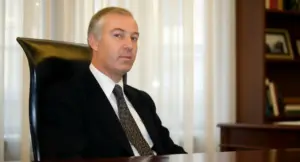 Un uomo in giacca e cravatta seduto a una scrivania in un ufficio formale