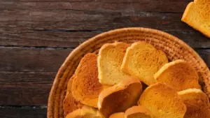 Cestino di fette biscottate dorate su tavolo di legno rustico