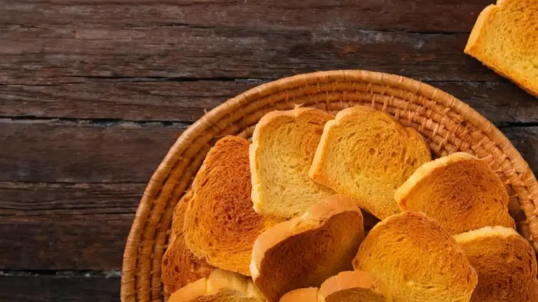Cestino di fette biscottate dorate su tavolo di legno rustico