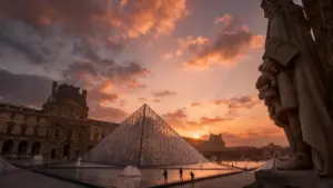 Piramide di vetro del Louvre al tramonto con alcune persone in primo piano