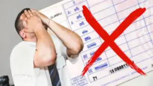 Persona con le mani sul viso davanti a una patente con una grande X rossa