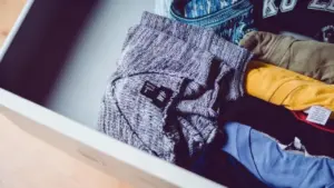Cassetto aperto con abiti piegati di vari colori