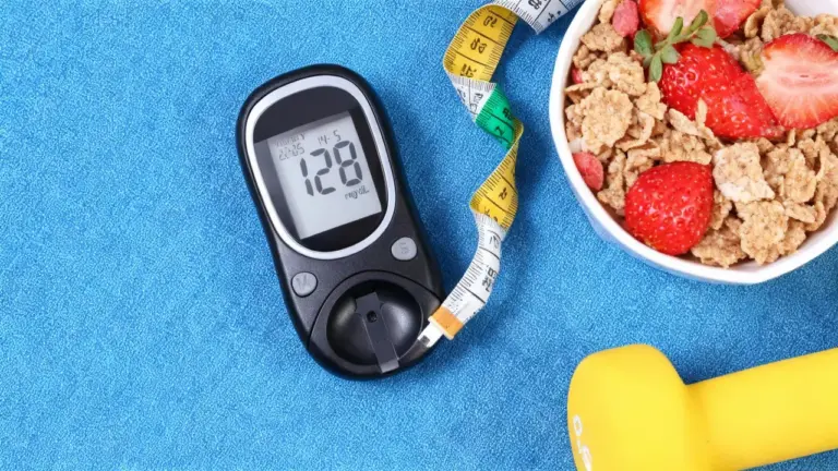 Un misuratore di glicemia accanto a una ciotola di cereali e fragole, metro da sarta e un manubrio giallo