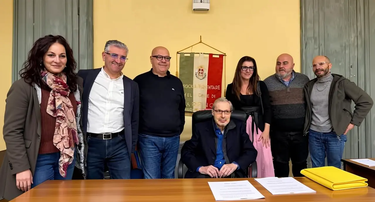 Un gruppo di persone riunite intorno a una scrivania in un ufficio comunale