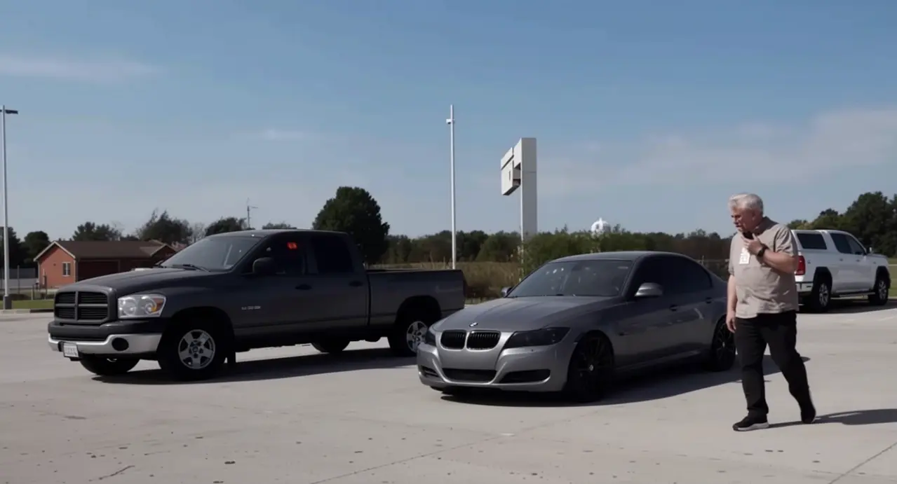 Parcheggio con auto ferme e una persona che cammina vicino a un'auto grigia