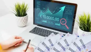 Una persona davanti a un laptop con grafico e cifra di 10.000 euro sullo schermo