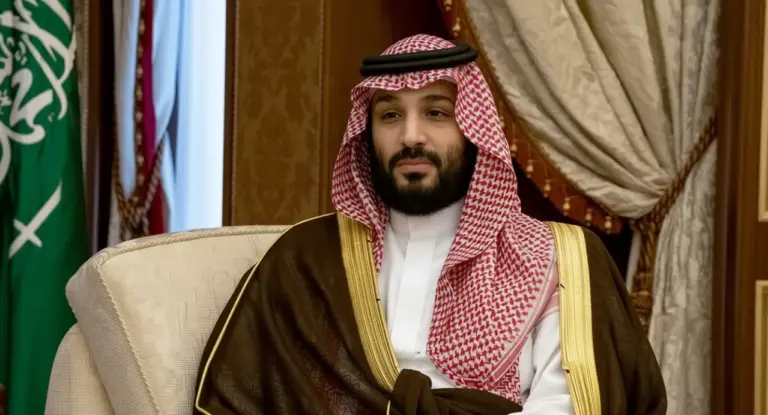 Un uomo in abiti tradizionali sauditi seduto su una poltrona in un ambiente formale