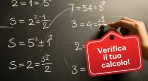 Mano che scrive formule matematiche con gesso su una lavagna nera