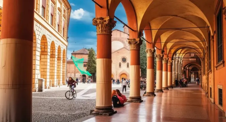 Portici storici di Bologna con persone sedute e un ciclista in piazza