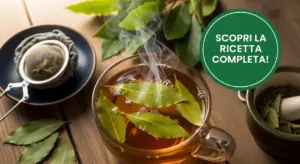 Tazza di infuso caldo con foglie di alloro fresche e utensili per tisane su tavolo di legno