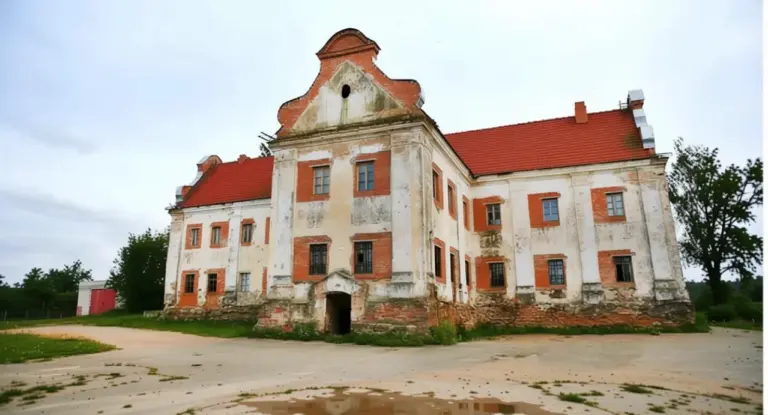 Edificio storico con facciata deteriorata e tetto rosso in mezzo alla campagna
