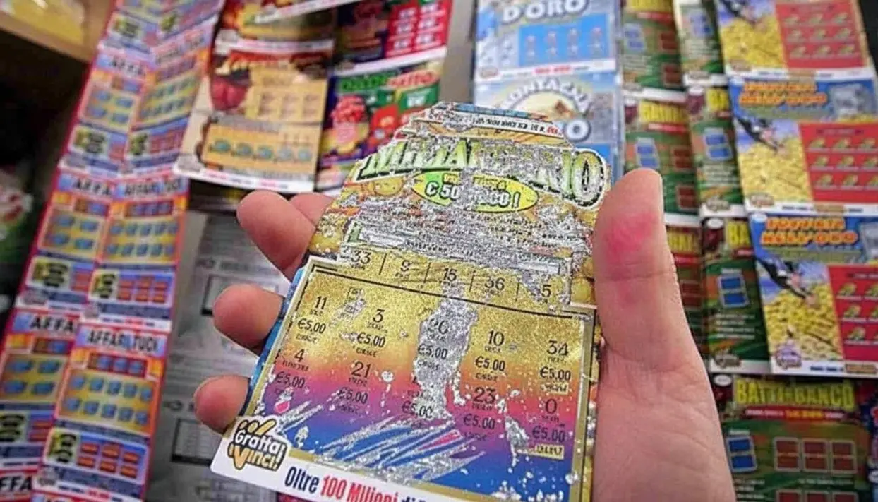 Una mano tiene un gratta e vinci parzialmente grattato in un punto vendita.