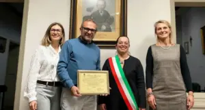 Quattro persone in posa con un attestato in un ufficio comunale