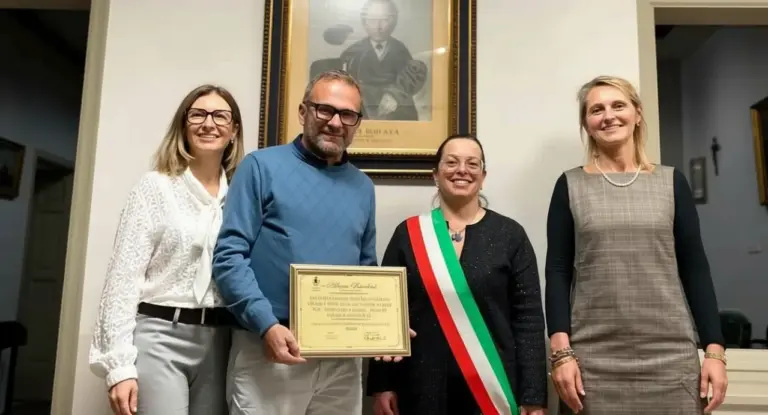 Quattro persone in posa con un attestato in un ufficio comunale