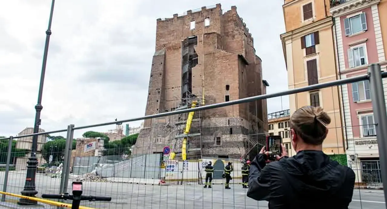 La Torre dei Conti a Roma circondata da impalcature e operai durante lavori di restauro